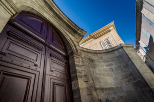 Large wooden door in the old town centre of Beziers in summer Large wooden door in the old town centre of Beziers in summer